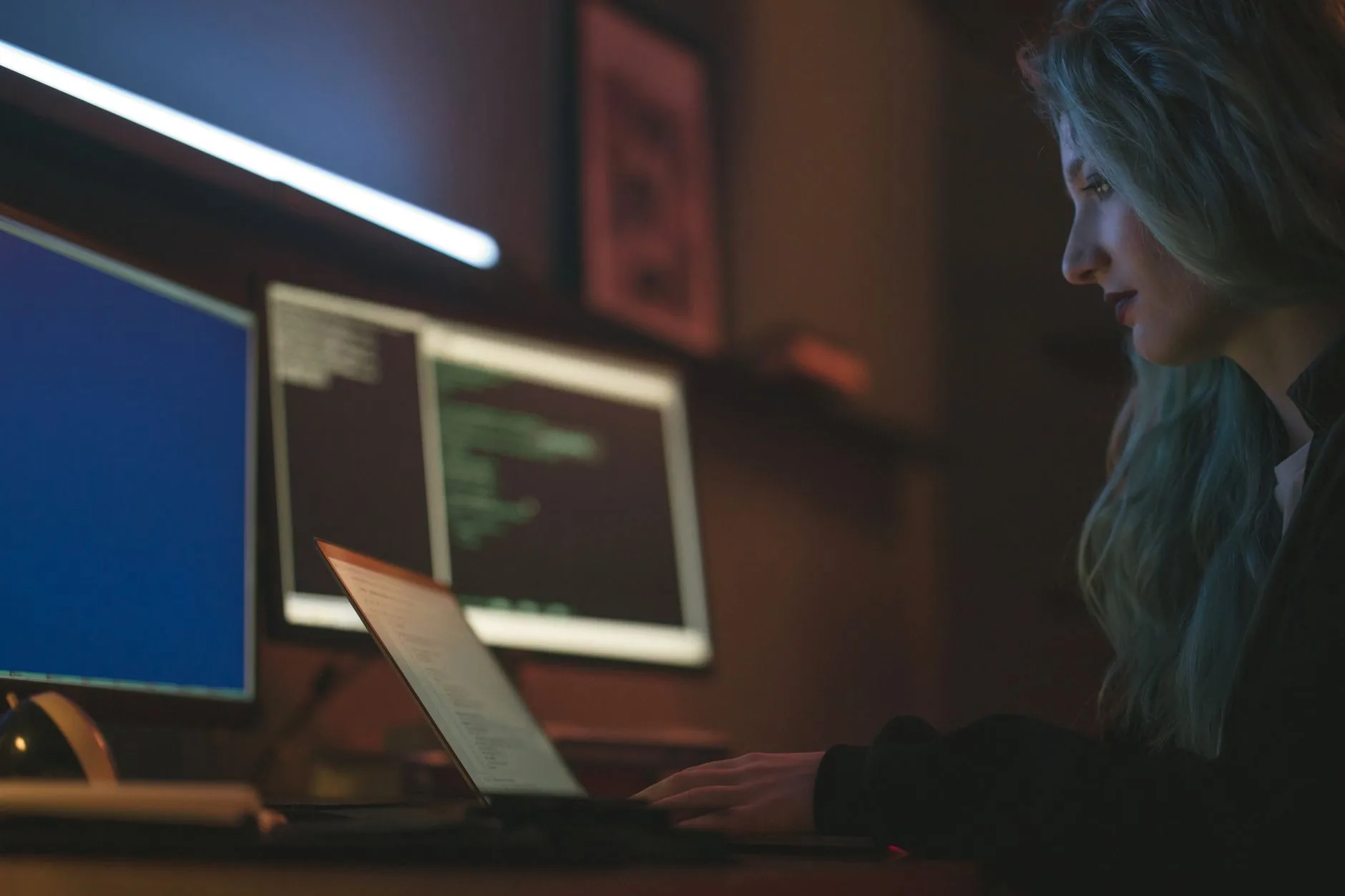 Analista de SOC monitorando múltiplos telões com dashboards de alertas de segurança e logs em tempo real